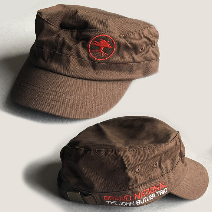 Two brown caps with the 'Grand National' and 'John Butler Trio' text and logo on them, displayed from different angles.